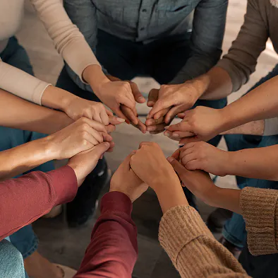 Team of professionals joining hands together representing collaboration and support